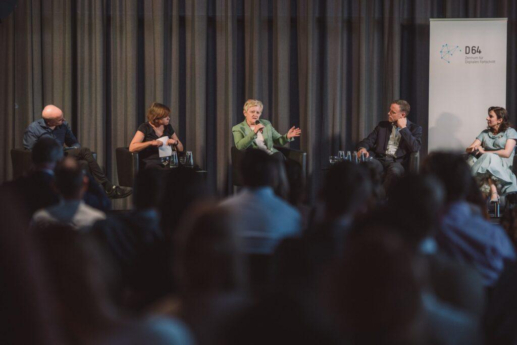 Ein Podium mit Henning Tillmann, Ingrid Brodnig, Renate Künast, Dr. Markus Richter, Marina Weisband. Renate Künast spricht gerade und ist im Fokus des Bildes.